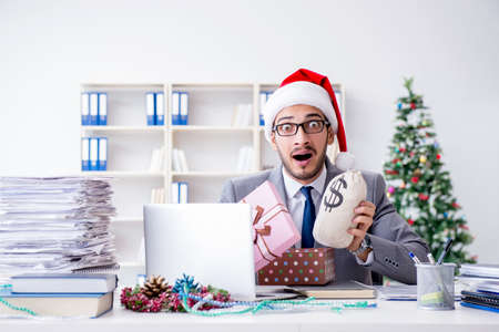 Young businessman celebrating christmas in the officeの写真素材