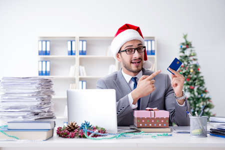 Young businessman celebrating christmas in the officeの写真素材