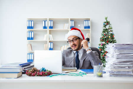 Young businessman celebrating christmas in the officeの写真素材