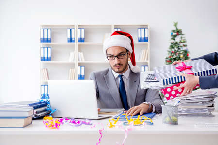 Young businessman celebrating christmas in the officeの写真素材