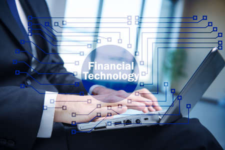 Hands working on laptop in financial technology fintech conceptの写真素材