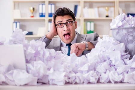 Businessman in paper recycling concept in officeの写真素材