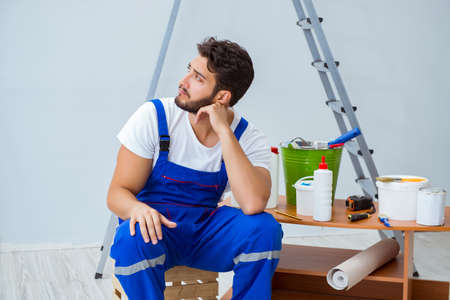 Repairman doing renovation repair in the house with paper wallpaの写真素材