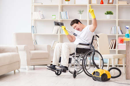 Disabled man with vacuum cleaner at homeの写真素材