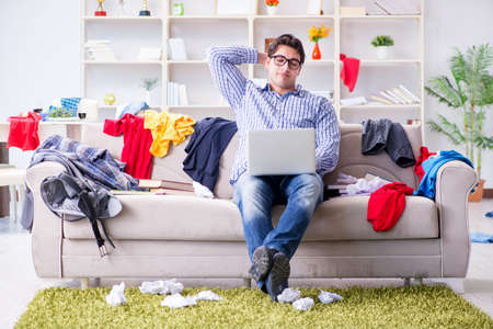 Young man working studying in messy roomの写真素材