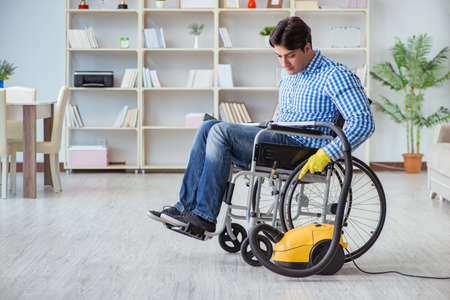 Disabled man cleaning home with vacuum cleanerの写真素材