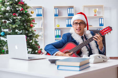 Businessman celebrating christmas holiday in the officeの写真素材