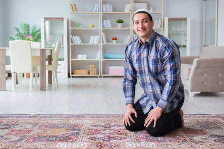 Young muslim man praying at homeの写真素材