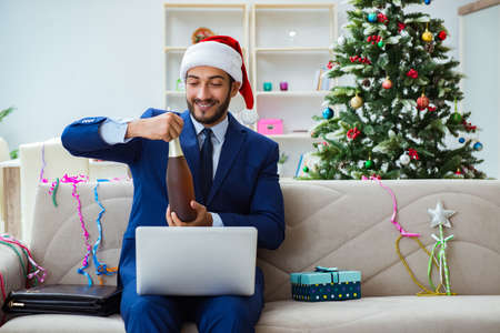Businessman working at home during christmasの写真素材