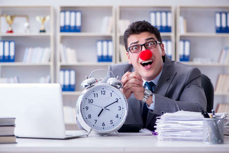 Clown businessman with alarm clock missing dieadlineの写真素材