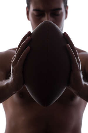 Ripped young man with american football isolated on whiteの写真素材