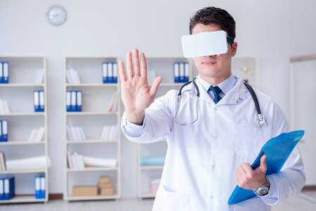 Young doctor with vr virtual reality headset working in the offi