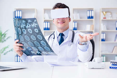 Young doctor looking at MRI scan through VR glassesの写真素材