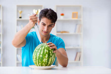 Man eating watermelon at homeの写真素材