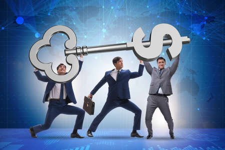 Businessmen holding giant key in finance conceptの写真素材