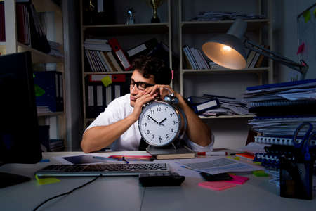Man businessman working late hours in the officeの写真素材