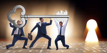 Businessmen holding giant key in business conceptの写真素材