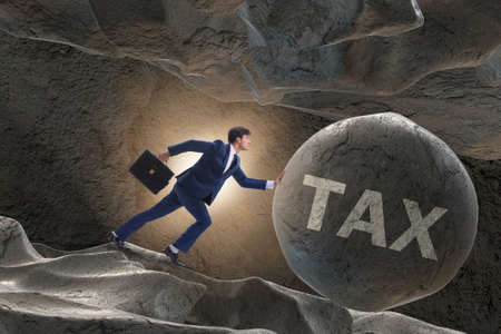 Businessman in high taxes business conceptの写真素材
