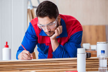 Yooung repairman carpenter working with paint painting