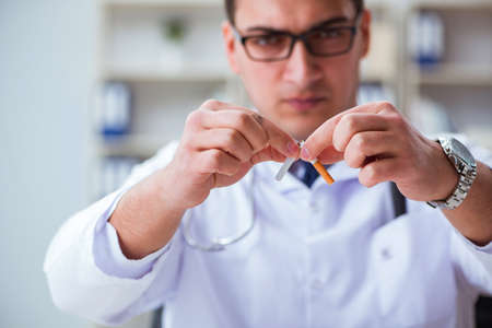 Male doctor in anti-smoking conceptwithcigarette packの写真素材