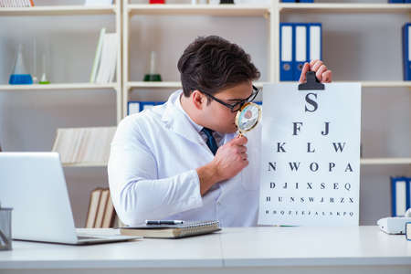 Doctor optician with letter chart conducting an eye test check