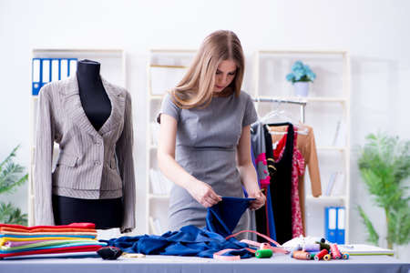 Young woman tailor working in workshop on new dress