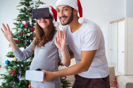 Young family expecting child baby wearing virtual reality VR gla
