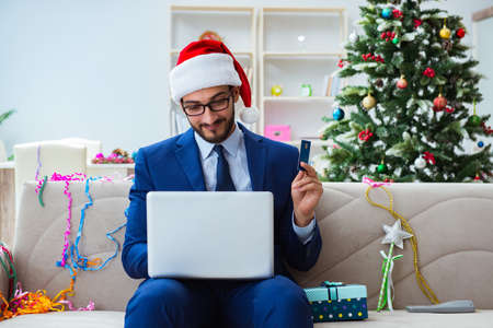 Businessman working at home during christmasの写真素材