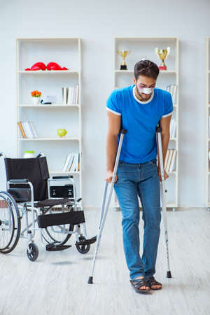 Young man recovering after surgery at home with crutches and a wの写真素材
