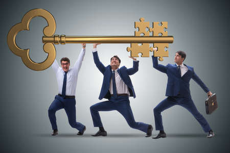 Businessmen holding giant key in business conceptの写真素材