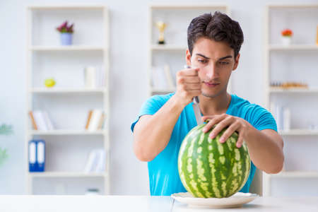 Man eating watermelon at homeの写真素材