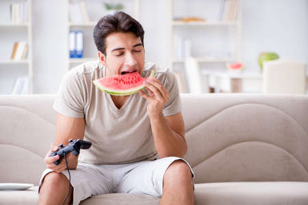 Man eating watermelon at homeの写真素材