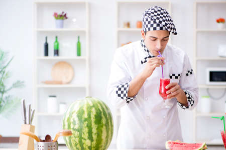 Male cook with watermelon in kitchenの写真素材