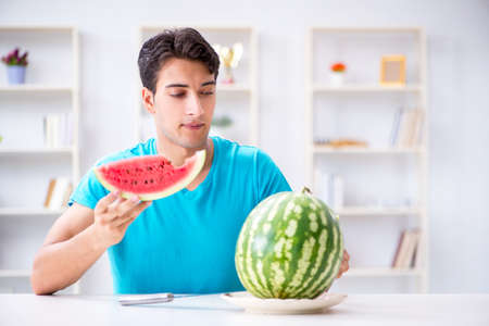 Man eating watermelon at homeの写真素材