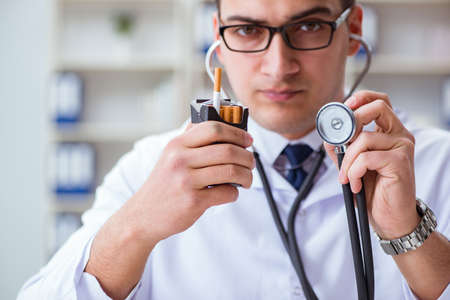 Male doctor in anti-smoking conceptwithcigarette pack