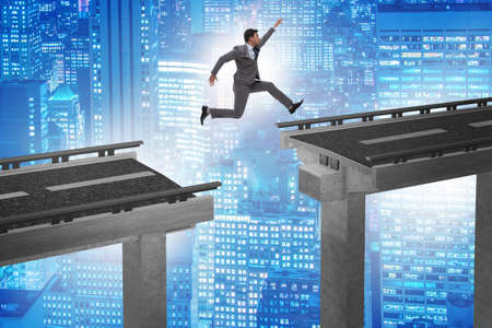 Young businessman jumping over the bridgeの写真素材