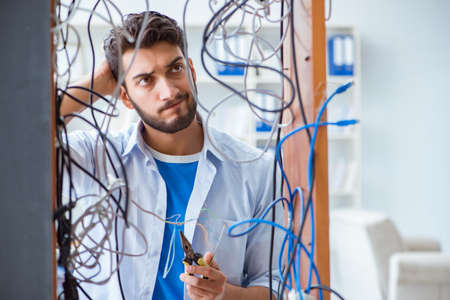 Electrician trying to untangle wires in repair conceptの写真素材