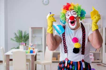 Funny clown doing cleaning at home