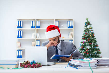 Young businessman celebrating christmas in the officeの写真素材