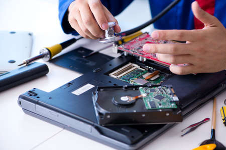 Repairman working in technical support fixing computer laptop tr