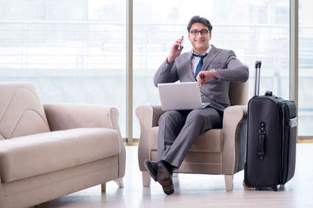 Young businessman in airport business lounge waiting for flightの写真素材