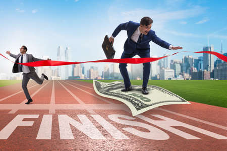 Businessman flying on dollar banknote towards finish lineの写真素材