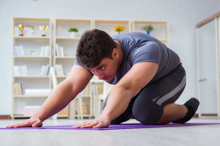 Young man exercising at home in sports and healthy lifestyle conの写真素材