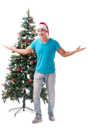 Young man decorating christmas tree isolated on whiteの写真素材