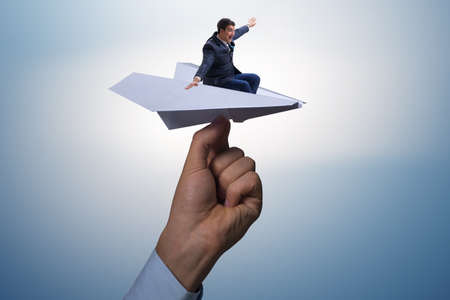 Businessman flying on paper plane in business conceptの写真素材