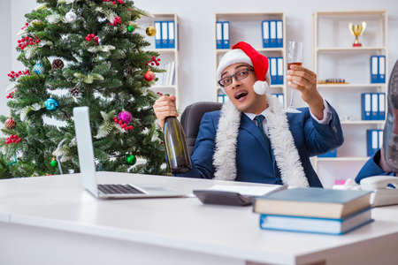 Businessman celebrating christmas holiday in the officeの写真素材