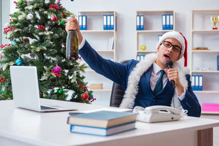 Businessman celebrating christmas holiday in the officeの写真素材