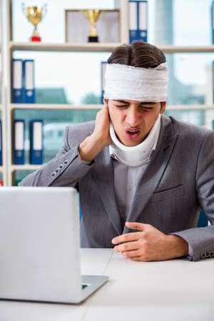 Injured businessman working in the officeの写真素材