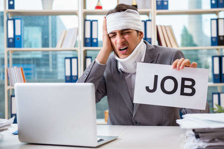 Injured businessman working in the officeの写真素材