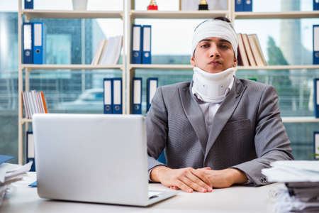 Injured businessman working in the officeの写真素材